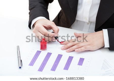 A woman painting her nails red at work