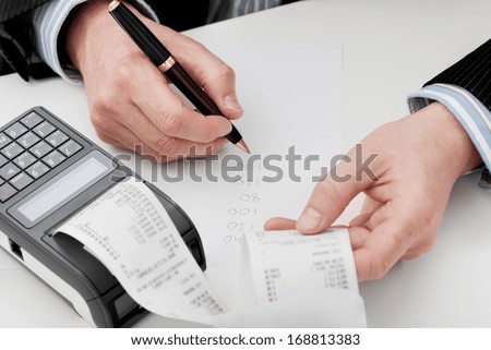 An accountant going through company\'s finances summing up the expenses