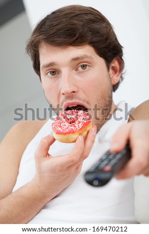 Man with donut and TV remote control