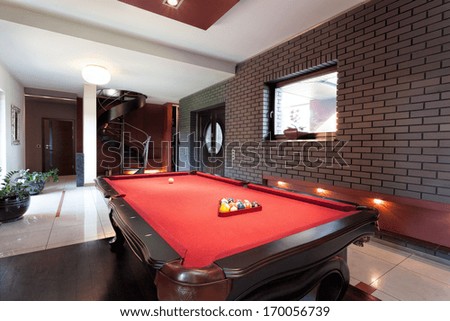 A big red pool table in a luxurious interior