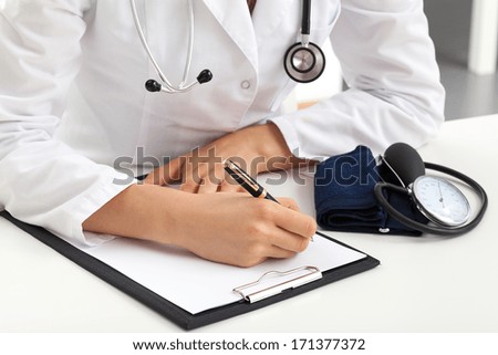 Doctor writing down notes about patients examination