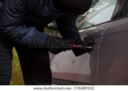 Man wearing a gloves tryng to break into the car