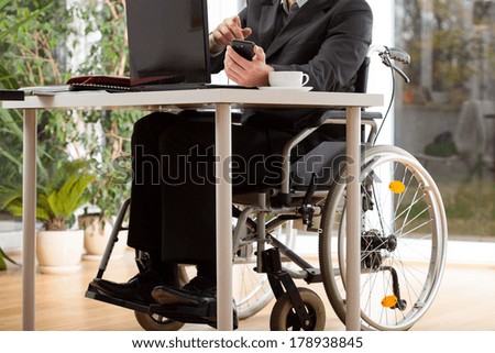 A businessman on a wheelchair working in his office