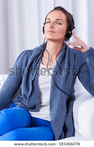 Young woman listening to good music, vertical