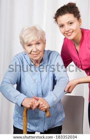 Nurse with elderly woman walking on crutches