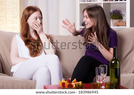 Two girls at meeting, chatting and laughing