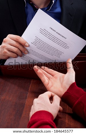A closeup of a credit angreement document being given to a client
