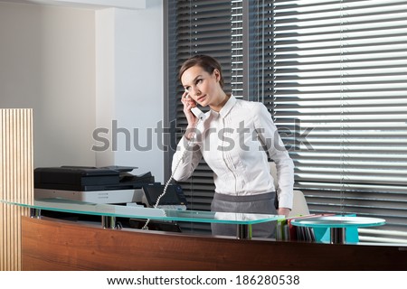 Beautiful secretary talking on the phone at office