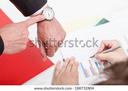 A man hurrying up his employee working on a graph