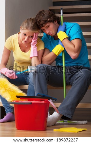 Young couple exhausted of cleaning big house