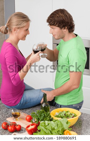 Couple at kitchen drinking wine and eating dinner