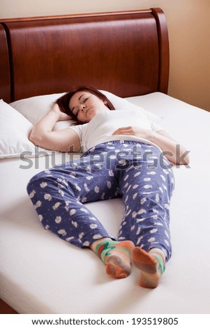 Young woman in pajamas taking a nap in bed