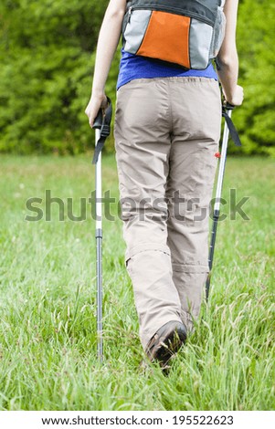 Close-up of female legs and nordic walking poles during walking