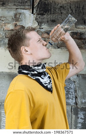 Vertical view of young boy drinking vodka