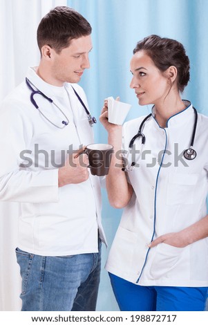 Young doctors drink coffee and talk during a break