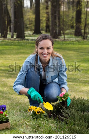 Portrait of a beautiful woman kneeling during working in garden