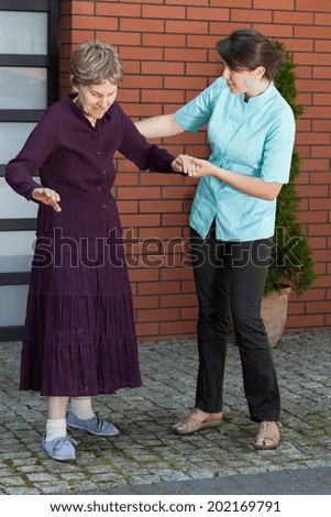 Elderly lady trying to walk alone, vertical