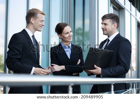 Team of business people talking in front of office building