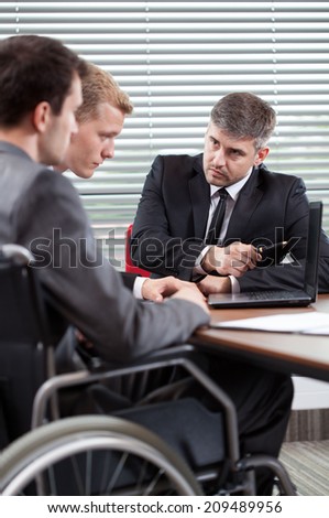 Disabled man and his co-worker talking with boss, vertical
