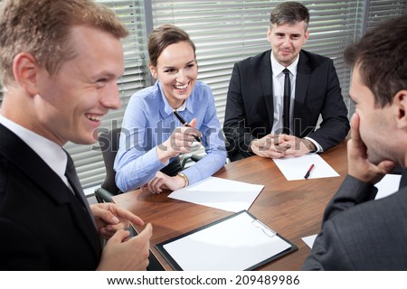 Business people laughing during business meeting, horizontal