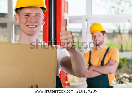 Blue-collar worker showing thumbs up sign, horizontal