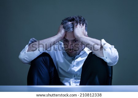 Horizontal view of depressed man at work