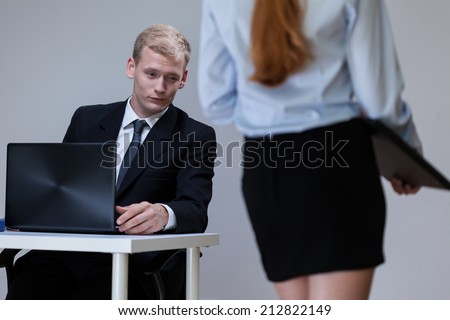 Man observing female co-worker\'s legs at work