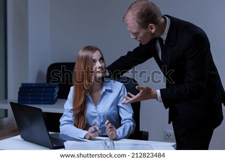 Mad boss talking with female worker, horizontal
