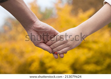 Couple holding hands in park during autumn walk