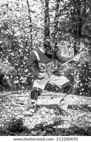 A gardener playing a rake guitar in black and white