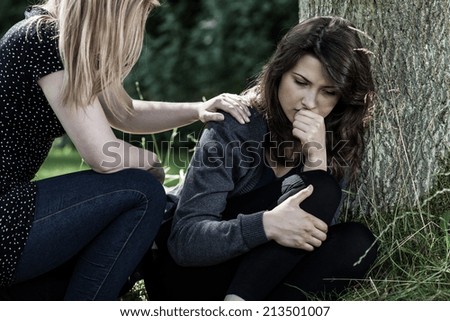 Young woman comforting her mourning friend