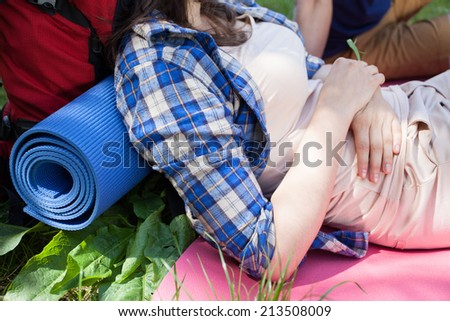 Woman with backpack resting on the grass