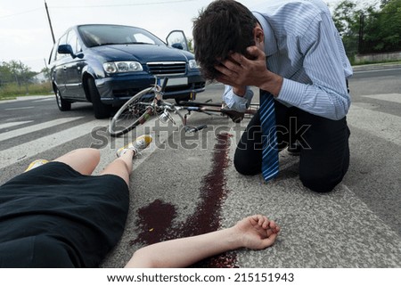 Crying driver and injured woman at road accident scene, horizontal