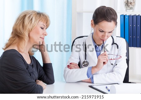 Young doctor analyzing problem of her middle aged patient