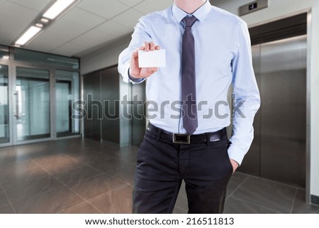 Businessman standing in office with his card in hand