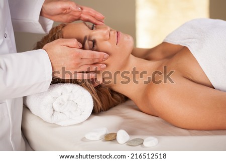 Woman having face massage in spa room