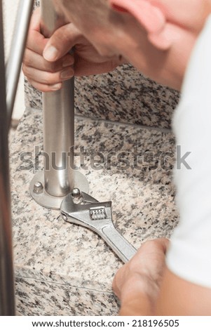Handyman tightening bolts using a wrench