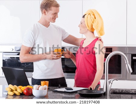 Busy couple during quick breakfast in the kitchen