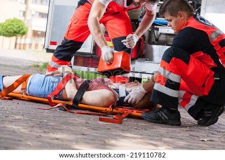 Paramedics giving first aid girl after accident