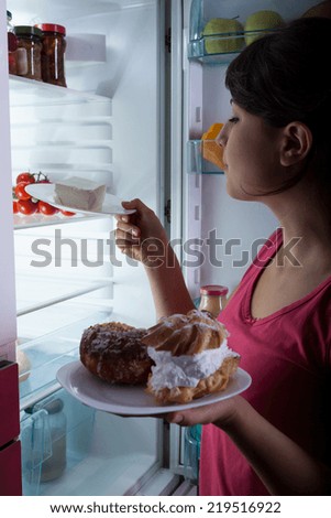 Hungry woman in the kitchen at the night
