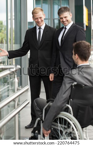 Business company workers help their disabled colleague
