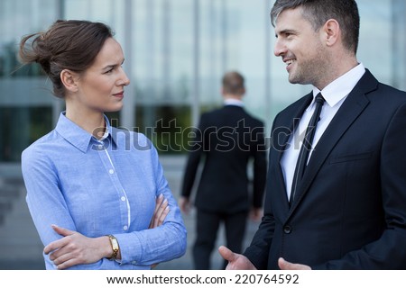 A man in formal clothing talking with his coworker