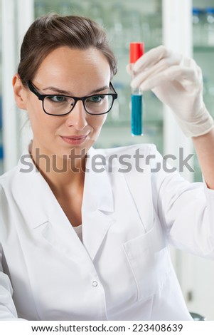 Chemist watching test tube with chemical reaction