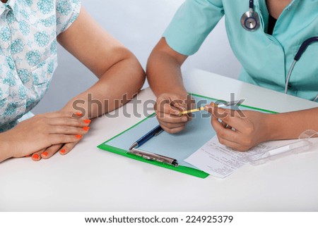 Doctor\'s hand showing patient a  medical syringe