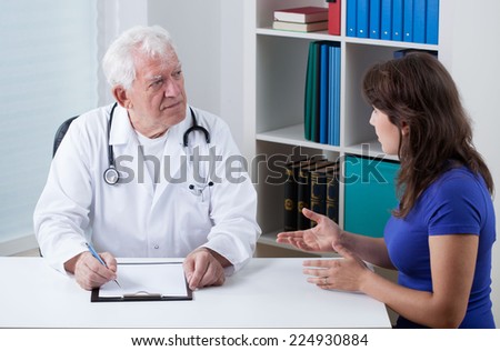 Practiced doctor talking with young female patient