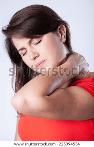 Young overworked woman with hurtful pain in the neck