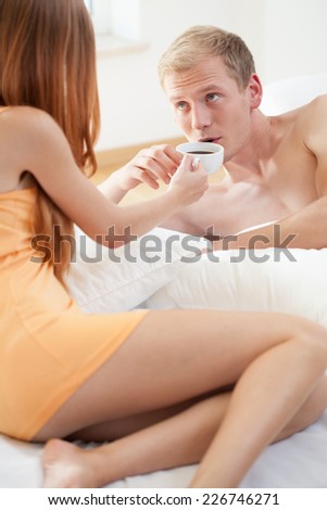 Young couple drinking morning tea in bed