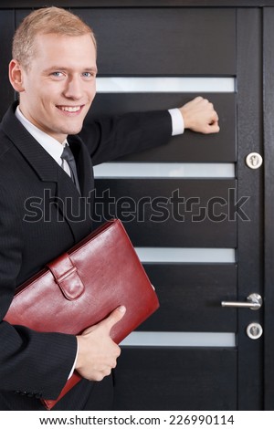 Portrait of door-to-door salesman knocking on the door