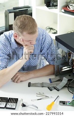 Young man having problems during computer repair