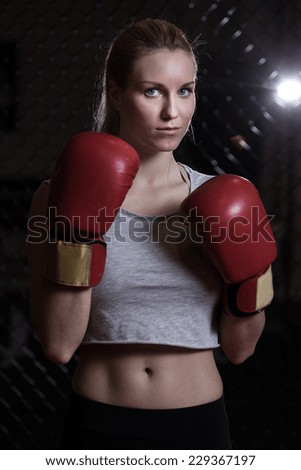 Young pretty woman with boxing gloves ready to box